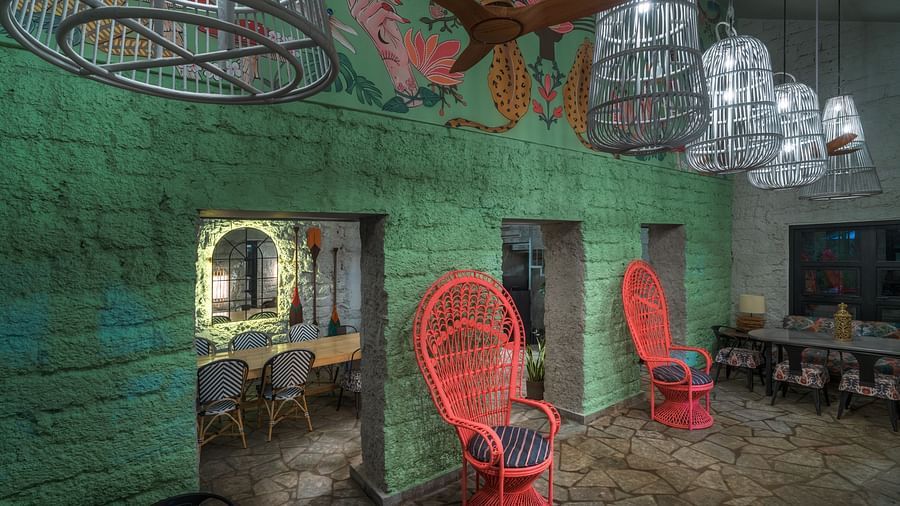 Red single seater in front of a green wall with a big dining table and seats inside - Village 36 - 27