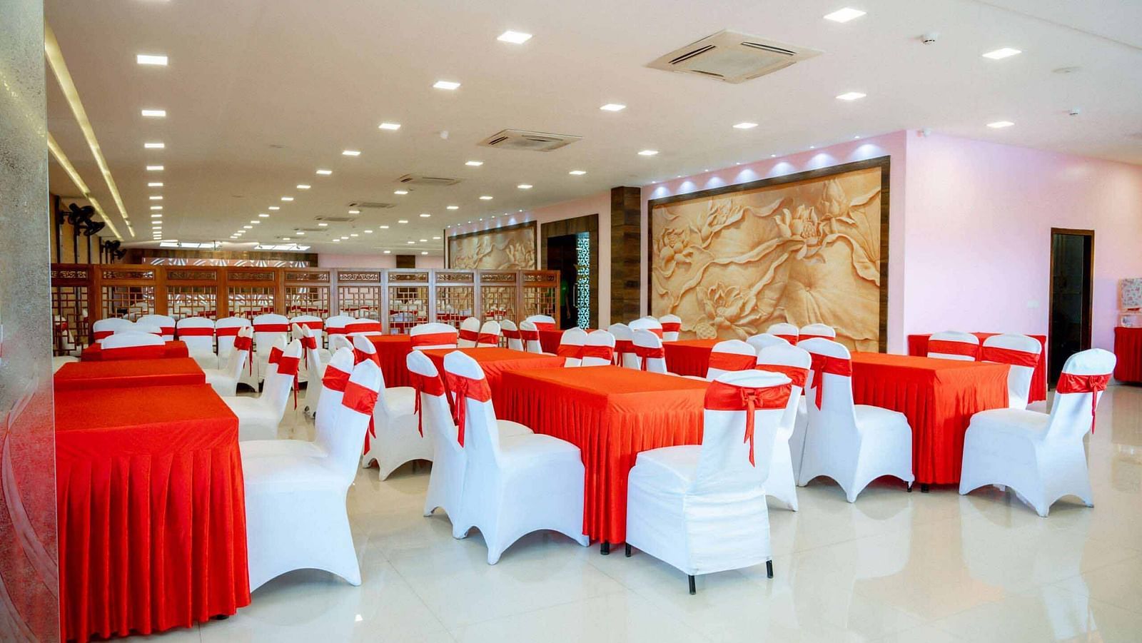 A banquet hall at Mansha Hotel Regency set up for an event, featuring round tables and white chairs.