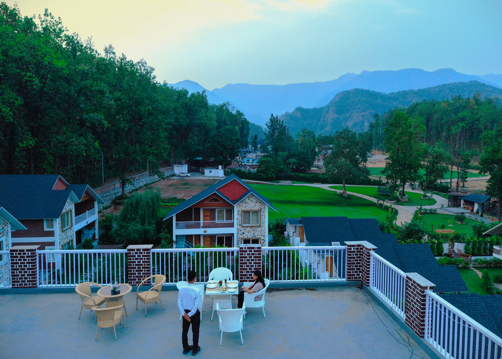 A rooftop seating area with panoramic mountain and garden views - Megha Resort & Villas, Dehradun