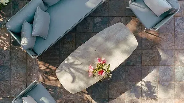 Overhead view of an outdoor seating area with a grey sofa, chairs, and a central table at Karma Chalets.