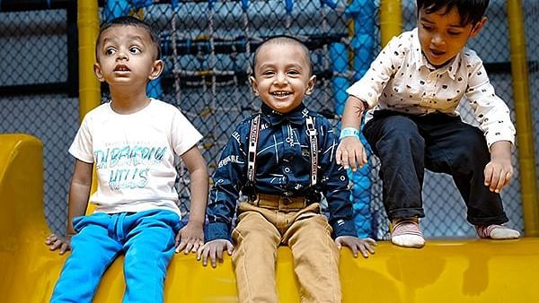 three kids sitting on a slide and posing for a picture - Diamond Parks, Pune 