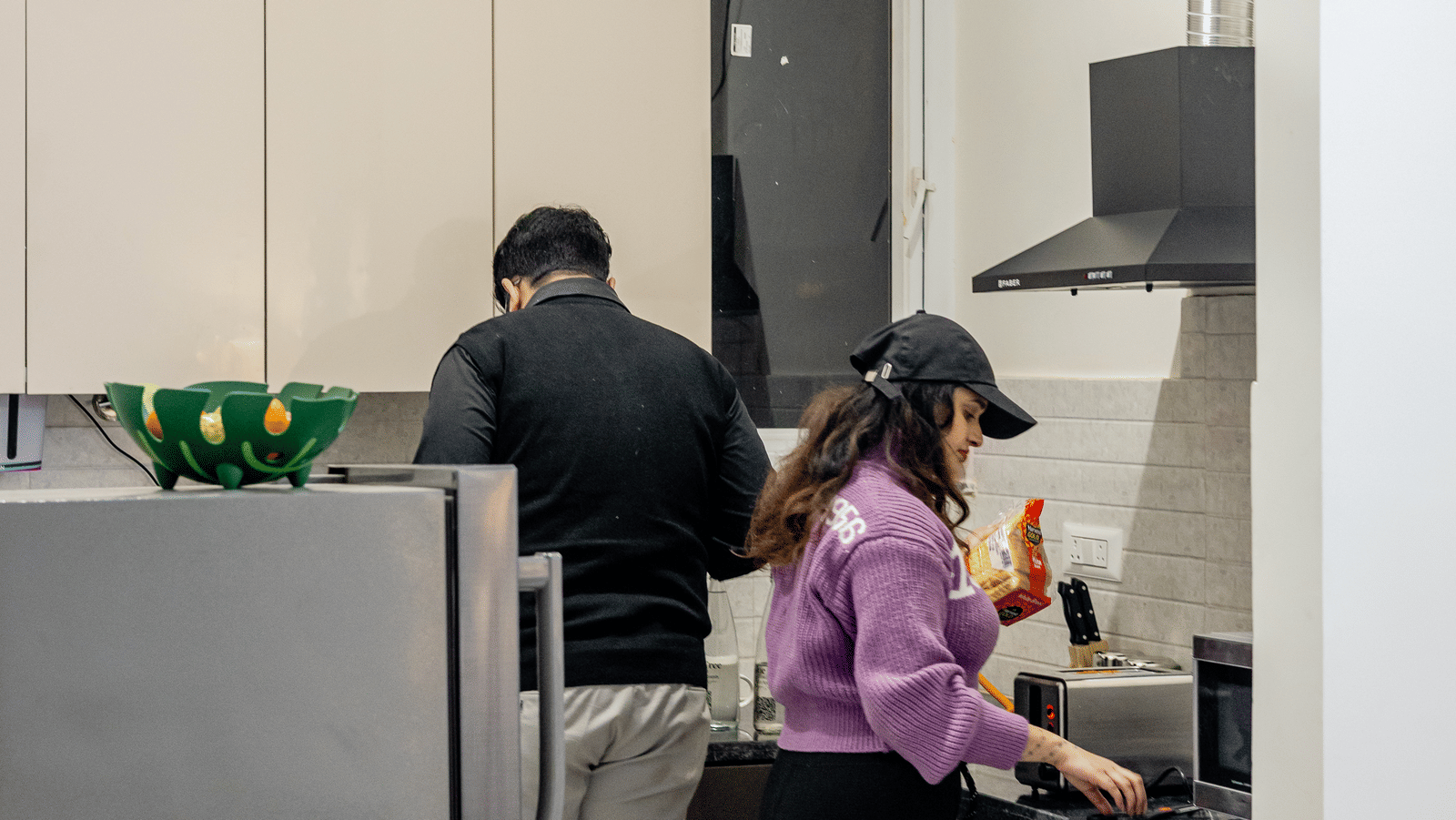 Guest and staff member standing near a kitchen counter at Lime Tree Hotels & Service Apartment Private Limited.