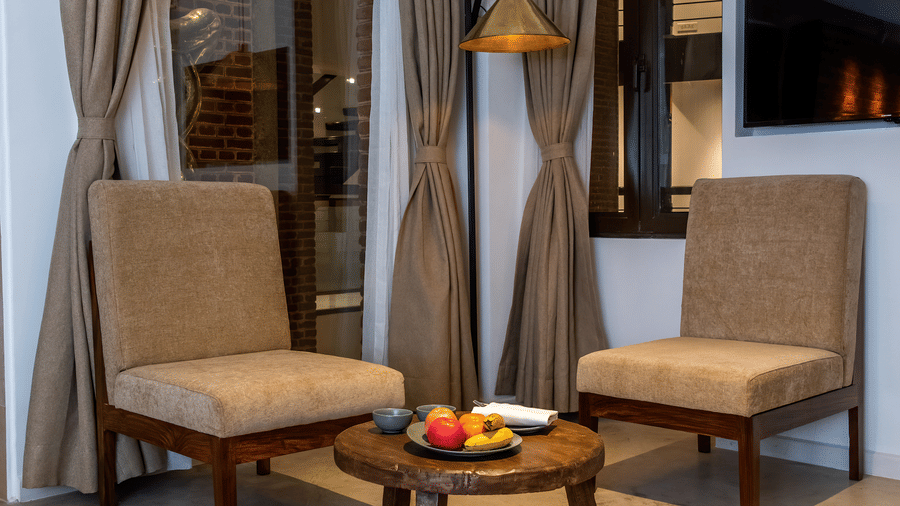 The room at The Nanee features chairs, a table, a flat-screen TV, and a rug.
