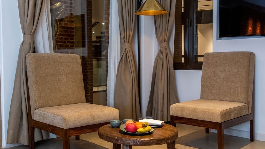 The room at The Nanee features chairs, a table, a flat-screen TV, and a rug.