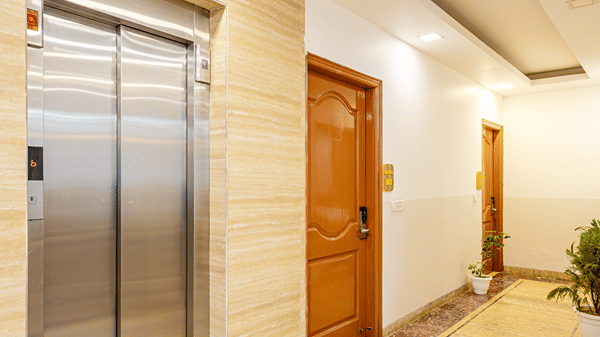 Hotel corridor featuring elevators and well-maintained interiors.