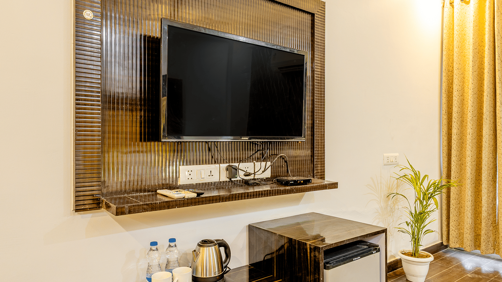 Hotel room featuring a wall-mounted television, work desk, and elegant décor.