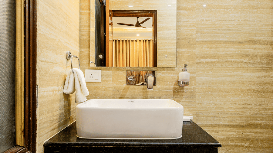 Contemporary hotel bathroom vanity with a wash basin and large mirror.