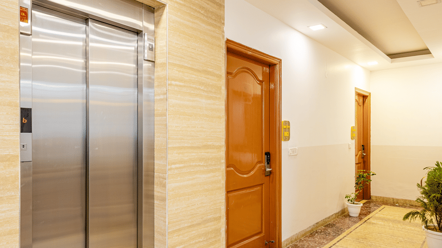 Hotel corridor featuring elevators and well-maintained interiors.