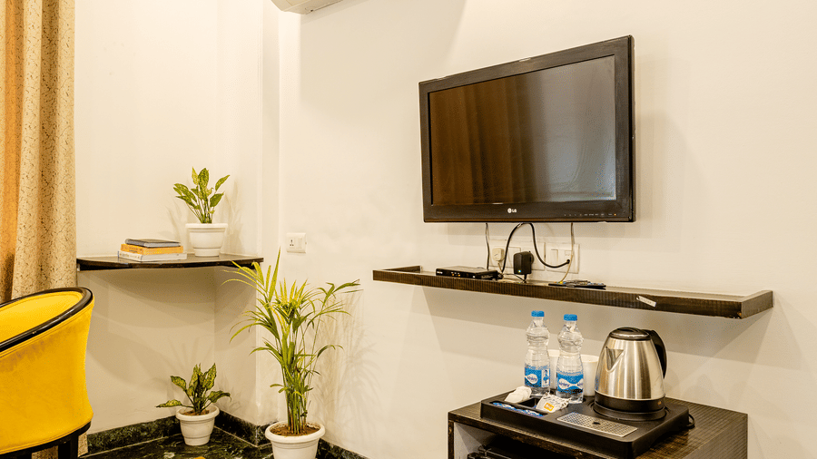 Modern hotel room with a television, work desk, and contemporary furnishings.