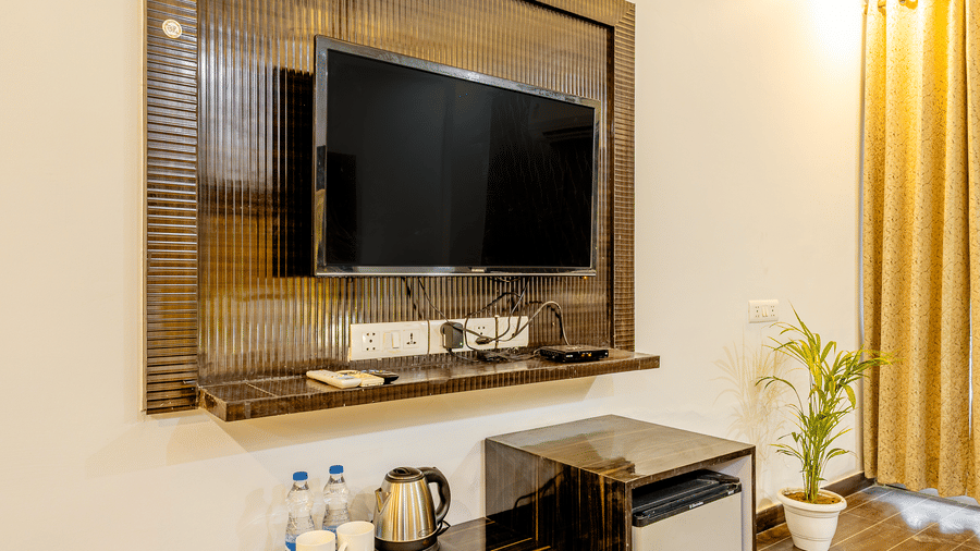 Hotel room featuring a wall-mounted television, work desk, and elegant décor.