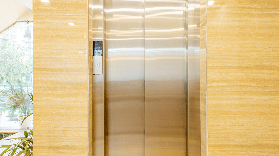 Modern hotel elevator with elegant interiors and marble flooring.