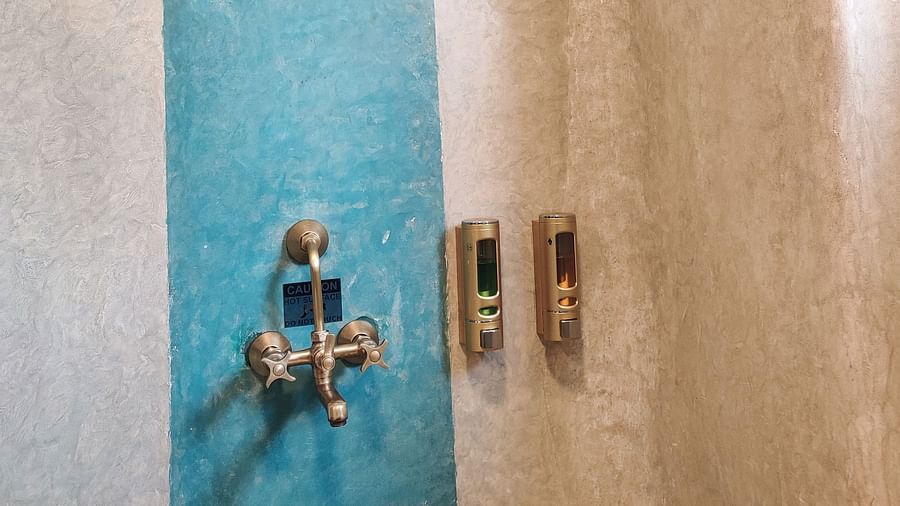 Ocean washroom with a blue part painted on the wall where the shower head and tap are placed.