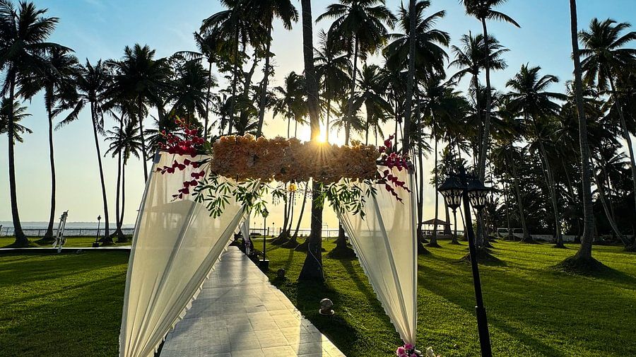 An outdoor pathway with a floral arch leading to the hotel building at Silver Sand Sea Princess Beach Resort, Port Blair.