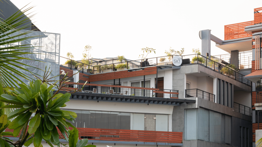 Exterior view of the tiered sections of the Hotel Sonar Bangla, Taki building and surrounding terraces with plants.