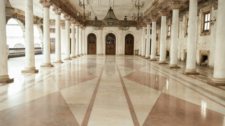 An interior view of Rajwada Palace, Indore, Madhya Pradesh, with a chandelier on the roof and numerous beams. This palace is one of the beautiful places in Indore to visit.