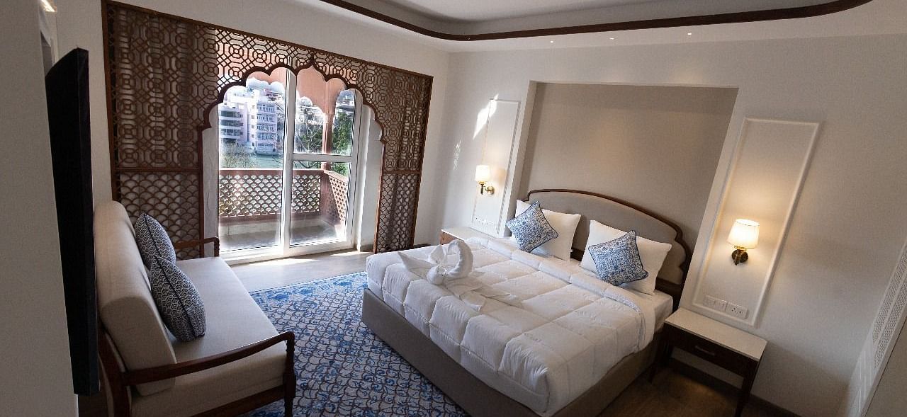 Top view shot of the Jalrupa Room featuring a double bed and a small balcony with huge french windows at Bhagirathi by RDB Atishay.