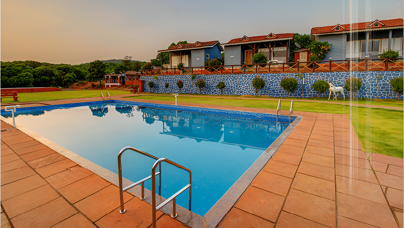 Sparkling pool beside a modern resort with terrace seating at De Soul Santé Hotels & Resorts.