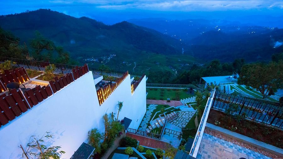 Aerial view of the hotel nestled among trees, with a breathtaking mountain vista in the background.