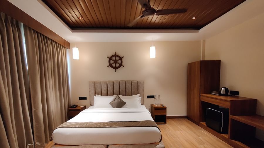 Side view of the room showcasing the veranda with sliding glass doors and greenery