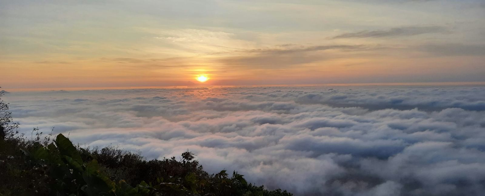 Nandi Hills in Chikaballapur, Karnataka, showing greenery and clouds.