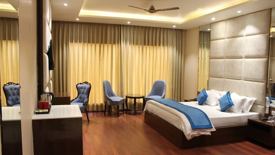 View of Deluxe room with bed and bedside tables seating area with windows and curtains  - Mastiff Hotel, Dalhousie