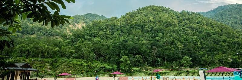 View of the swimming pool during the day at DLS MJ River Resort, Rishikesh.