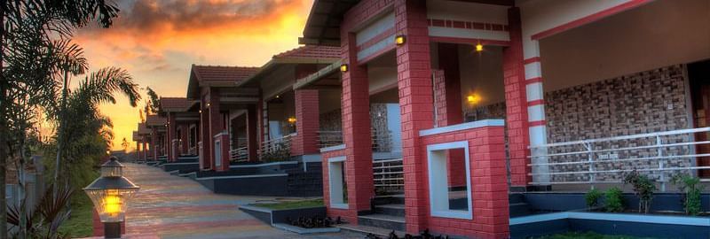 Facade of the resort with tiled passage, greenery and sunset | Main Passage | Woodstock Resorts, Coorg