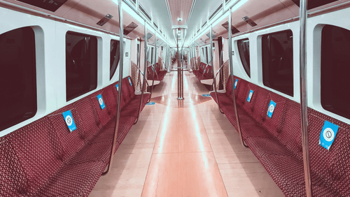Interiors of an empty metro train with all the windows blacked out.