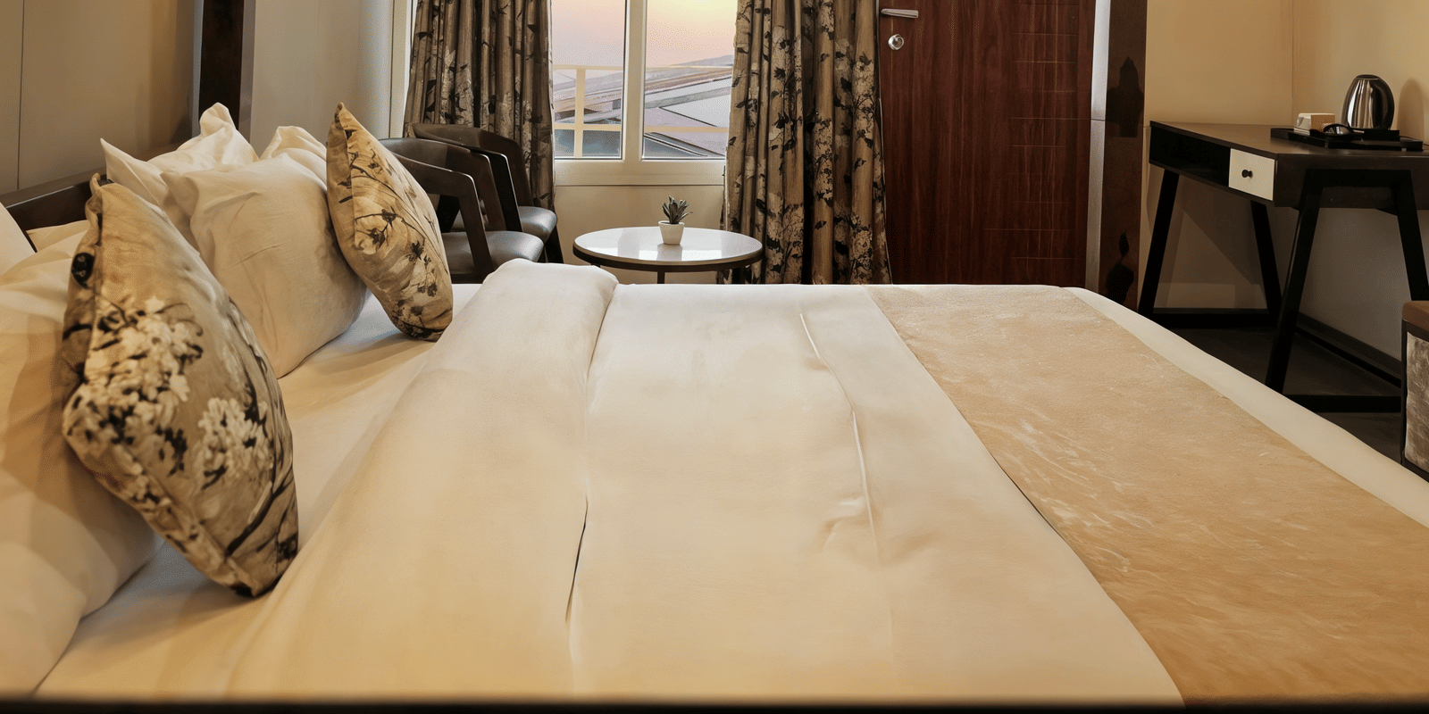 A cropped view of the Superior Room's bed and balcony railing in soft evening light at Nazaara Nature Retreat, Dalhousie.