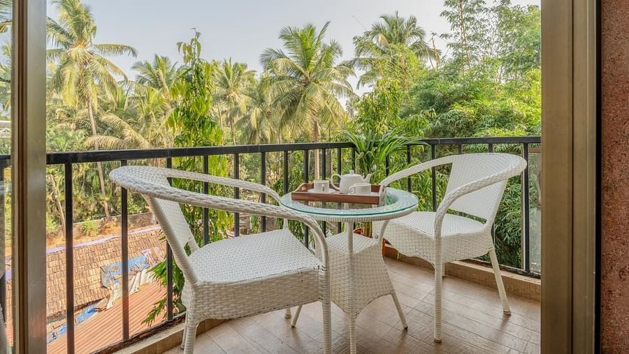 Image of the balcony at Grand Room with two chairs and a table at Calux Joia Do Mar Resort, Goa.