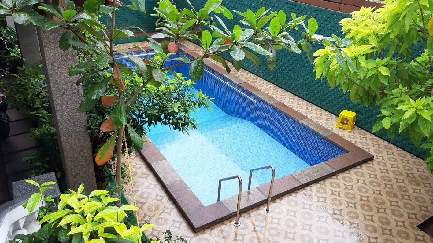 Image of a an outdoor swimming pool with trees on the side at Villa Serenity Le Sejour Pondicherry.
