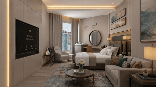 Spacious suite at Tulip Inn Bidar featuring a bed, sofa lounge area with a round coffee table, wall-mounted television, and desk with a circular mirror.