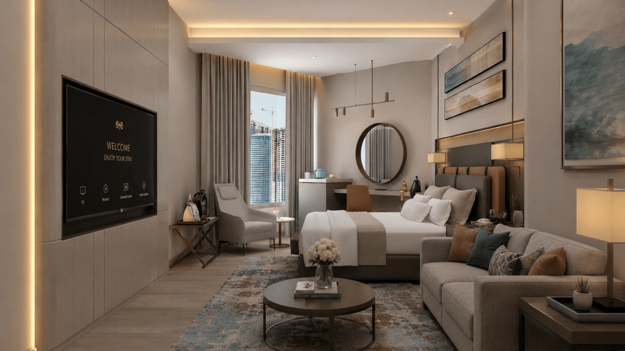 Spacious suite at Tulip Inn Bidar featuring a bed, sofa lounge area with a round coffee table, wall-mounted television, and desk with a circular mirror.