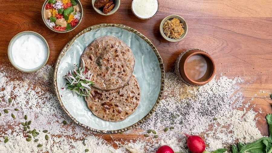 Flat lay of a plated dish with flat breads, dips, radishes, and herbs served at Karma Chalets.