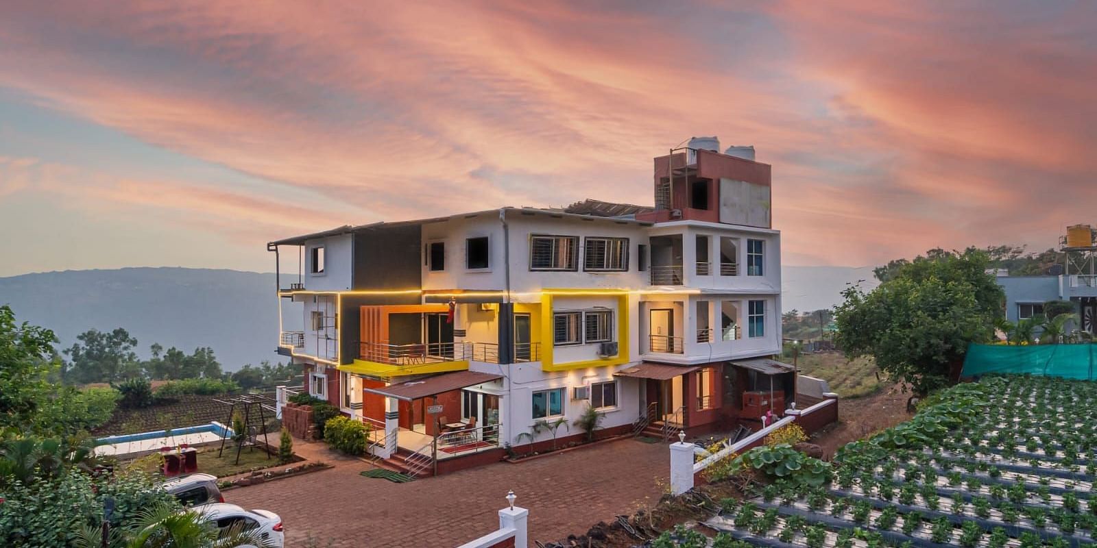 An exterior view of Strawberry King Resort, Mahabaleshwar at dusk.