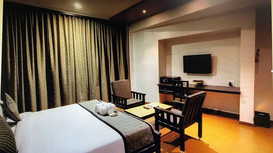 Damanganga Valley Resorts Pvt Ltd - the king size bed facing the TV and a small sitting space in the Executive Room in Daman