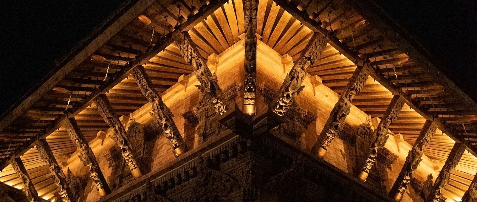 The carvings on a temple structure which is brightly lit
