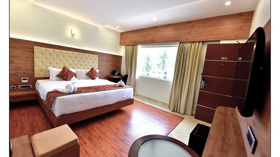 full view of standard room featuring a queen size bed and room amenities like a television a wardrobe etc. along with floor to ceiling windows - Royal Lotus View Resotel1