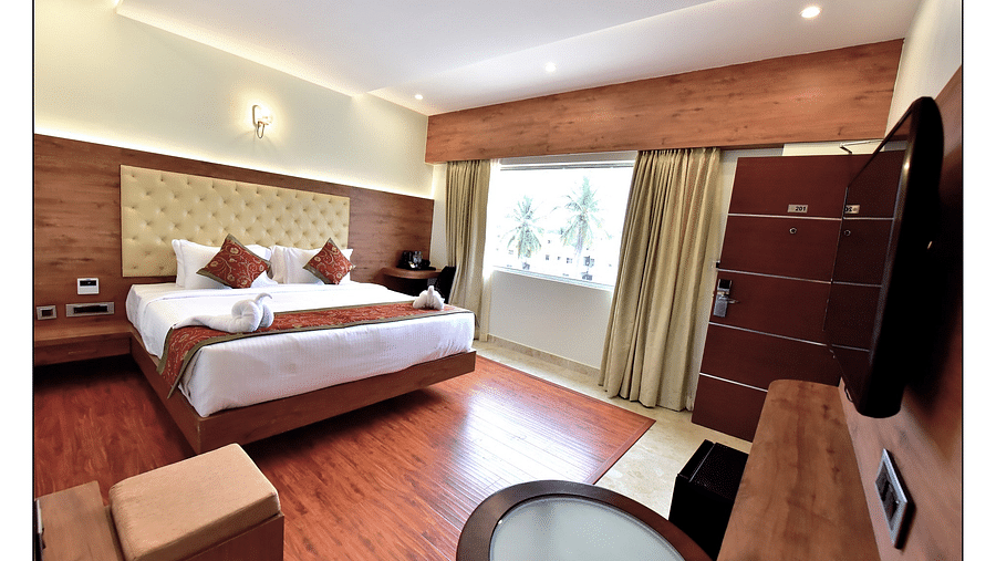 Royal Lotus View Resotel, Bangalore Bengaluru full view of standard room featuring a queen size bed and room amenities like a television a wardrobe etc. along with floor to ceiling windows - Royal Lotus View Resotel1