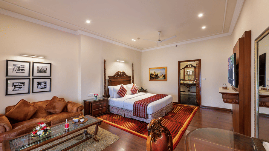 Luxurious Executive Suite at Mayfair Lagoon Bhubaneswar featuring a king-size bed, rich wooden furniture, classic artwork, and elegant warm-toned interiors