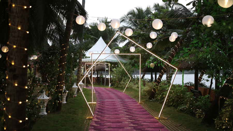 Walkway covered with white canopy and hanging lanterns at Paradise Lagoon Resort, Udupi.