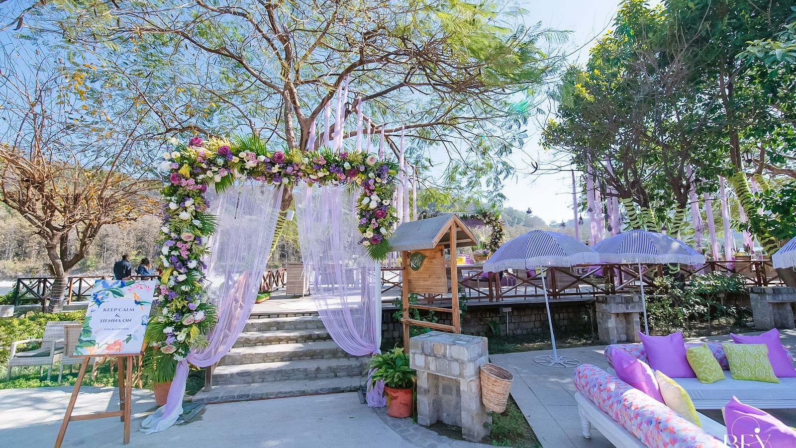  An image of a outdoor banquet hall with chairs, sofas and a stage decorated for destination wedding halls - Riverview Retreat, Corbett