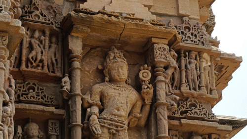 Stone carvings of the Sun Temple display sculpted pillars, ornate figures, and layered architectural details, showcasing skilled craftsmanship in warm sandstone tones.