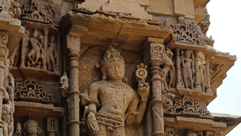 Stone carvings of the Sun Temple display sculpted pillars, ornate figures, and layered architectural details, showcasing skilled craftsmanship in warm sandstone tones.