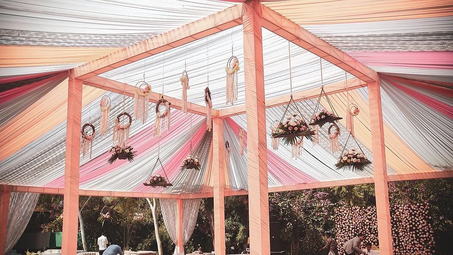 Outdoor event tent with colourful draped fabric ceiling, supported by a frame. - Bamboo Saa, Udaipur