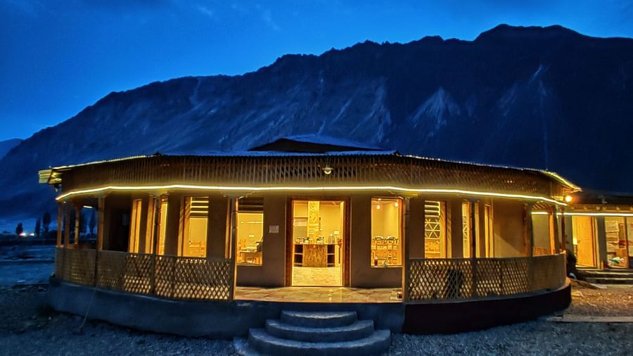 Exterior of the restaurant at White Sands Resort, Ladakh with warm lighting illuminating the structure against a dark, mountainous backdrop.