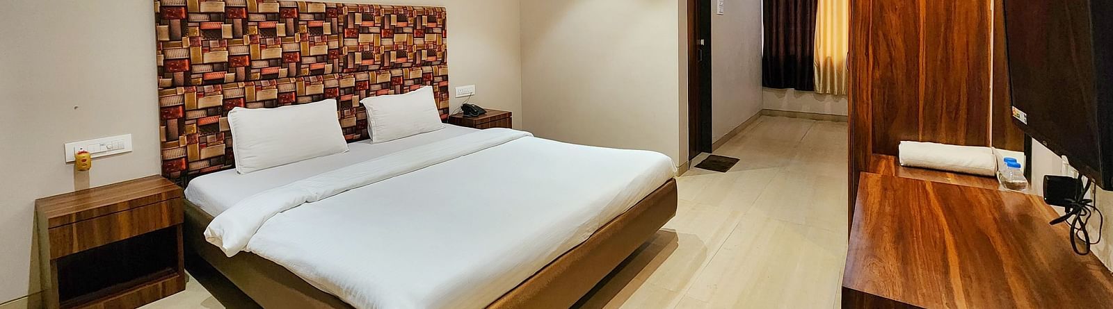 A Premium Room at The Kanila Resort featuring a bed, a desk, and a wardrobe.