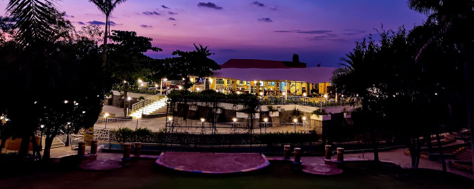 An evening view of the cafe which shows the blue sky and palm trees at the background | Diamond Parks, Pune