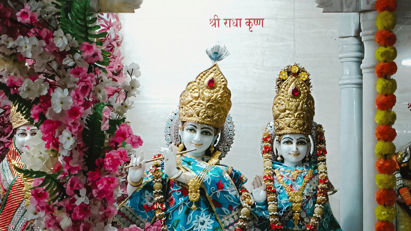 A photograph of two beautifully adorned statues of the Hindu deities Radha and Krishna.
