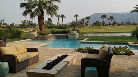 A beautiful landscape with a swimming pool along with a mountain range in the background.